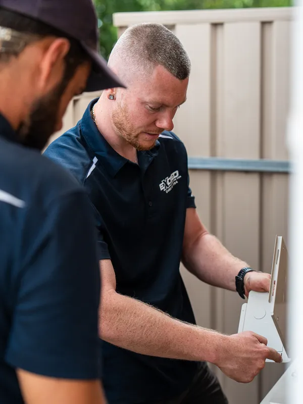 Technician fitting the wall bracket for a split system indoor unit